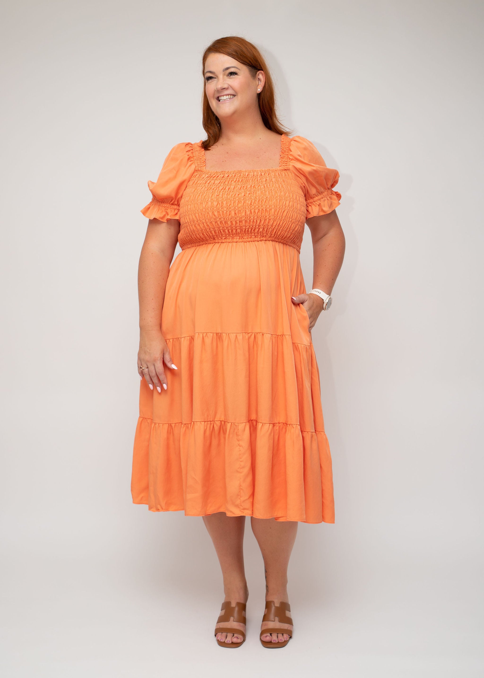 Coral tiered dress with puff sleeves, featuring shirring at the bodice and a flowing silhouette. A versatile and flattering piece from I Feel Pretty with practical pockets.