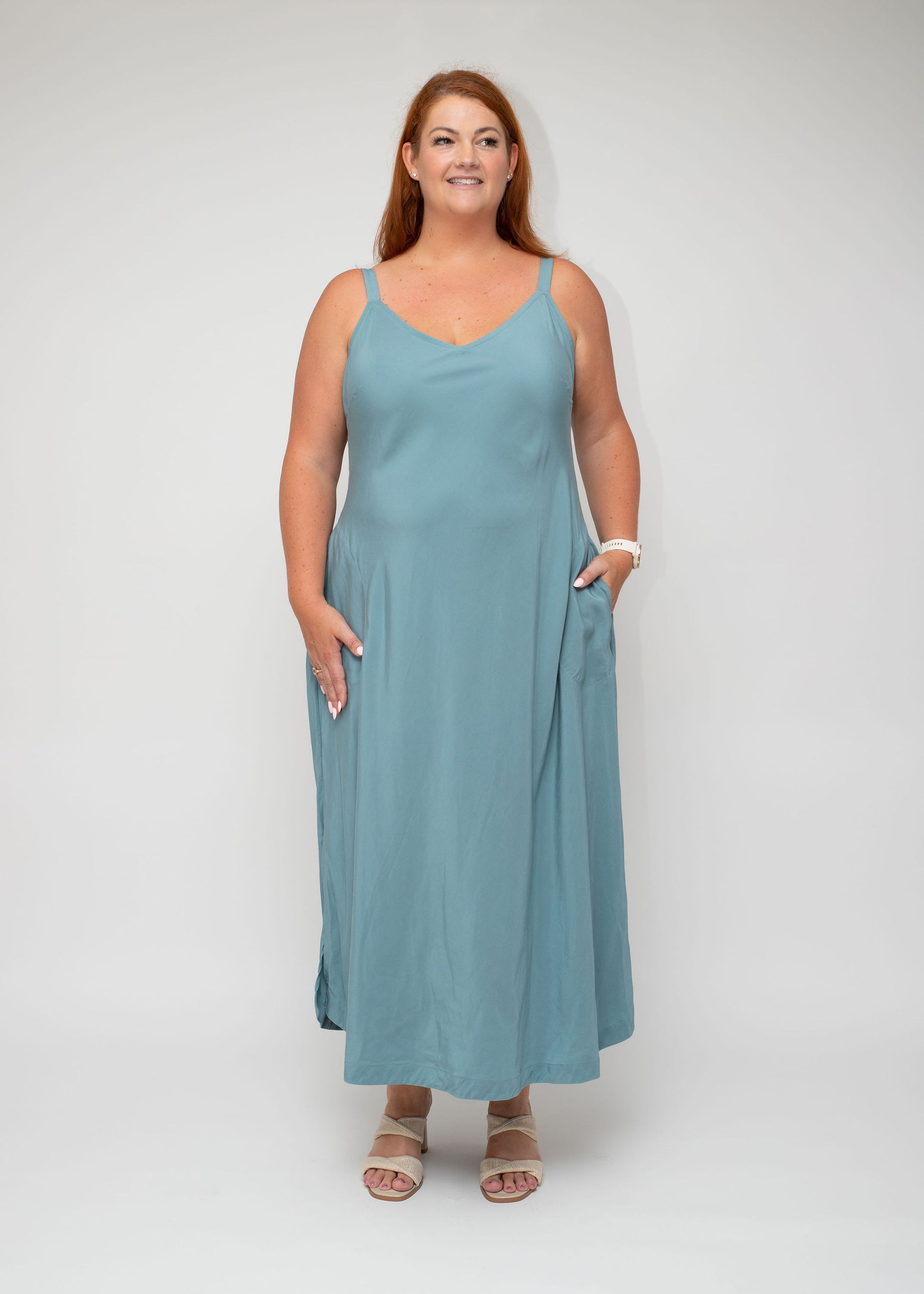 Front view of the Sage Green Slip Dress with V-neck design from the I Feel Pretty curvy collection, featuring a flattering silhouette and functional pockets.