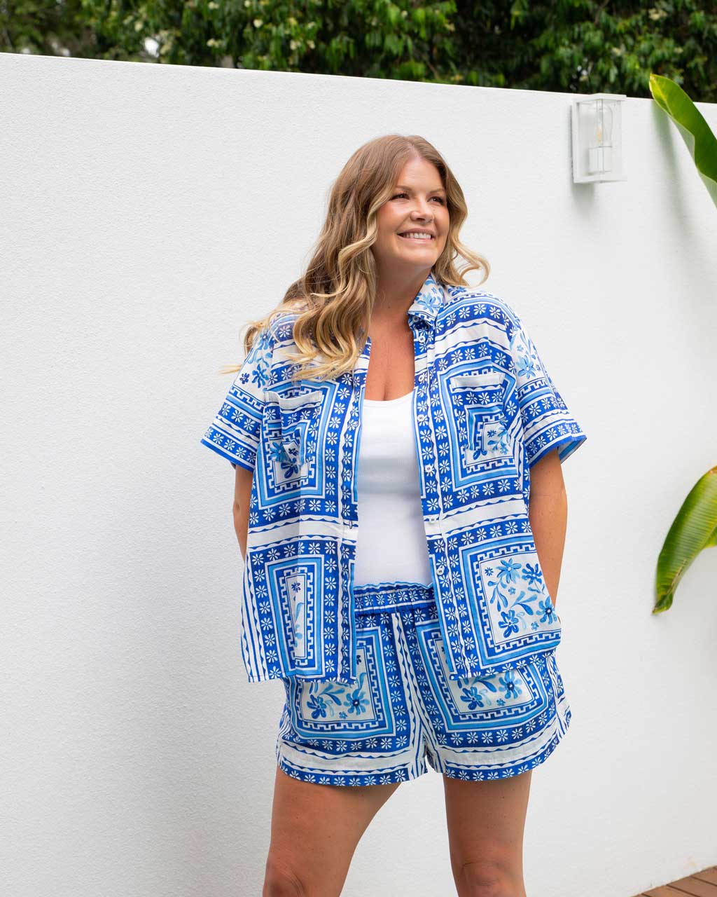 A woman in a Shasta Tile print matching shirt and shorts set standing outdoors against a white wall, highlighting breathable and stylish plus-size fashion by I Feel Pretty Boutique in Australia.